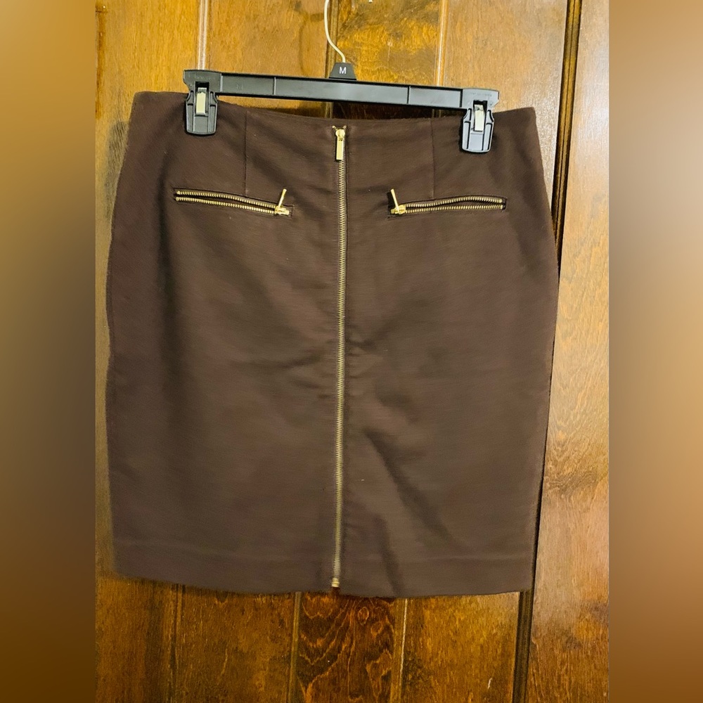 Brown skirt with gold zippers.